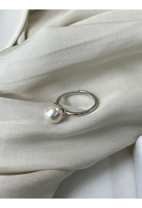 Dettaglio dell'anello in argento sterling S925 con perla bianca su tessuto di seta