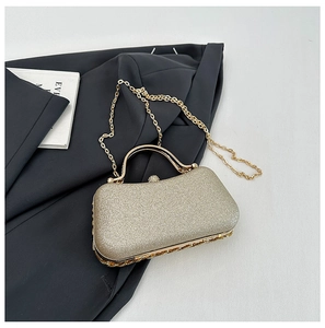 Detail of glitter champagne evening bag featuring round metal handle and diamond clasp