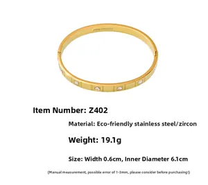 Detail of stainless steel gold bangle with round cubic zirconia inlays and inner engravings