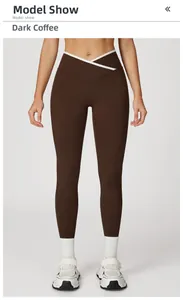 Detail van gekruiste V-hoge taille op diepbruine yoga legging met witte biezen