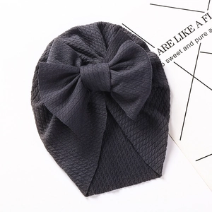 Detail of baby turban hat in dark grey waffle knit fabric with a large bow decoration