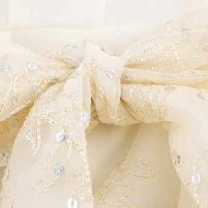 Robe ivoire élégante avec col en V, volants, broderies dorées et détails de paillettes