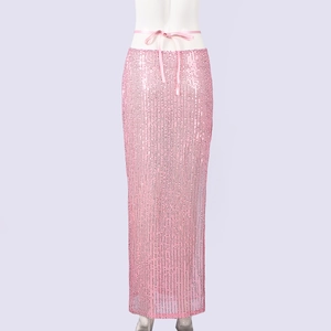 Dettaglio gonna lunga di paillettes rosa con nastro di raso in vita e texture lucida