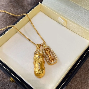 Dettaglio della collana Pixiu placcata in oro con zirconi su scatola per gioielli