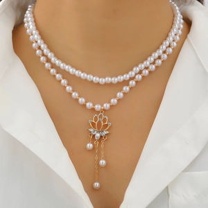 Elegant double-layered white pearl necklace featuring a golden lotus pendant charm