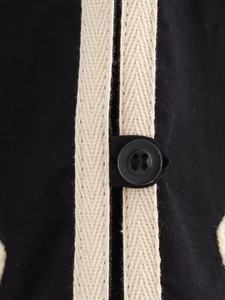 Détail macro du tissu en toile noire avec sangle à chevrons et bouton en résine noire