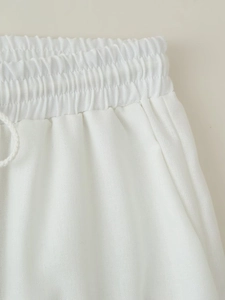 Detailed macro view of elastic waistband with drawstring on white cotton linen pants