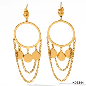 Détail de boucles d'oreilles créoles dorées avec chaînes pendantes et pendentifs ronds
