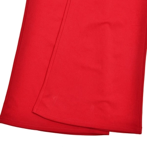 Gros plan sur la texture du tissu rouge montrant les coutures de qualité et le détail de l'ourlet