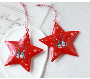 Detail of red tin star ornaments with gnome print and festive text on a white tray