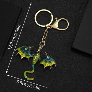 Detail of cartoon dragon keychain with green rhinestones and golden lobster clasp