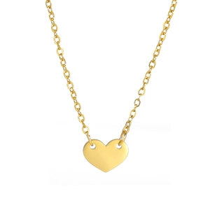 Gros plan du collier pendentif cœur doré minimaliste avec surface en métal poli brillant