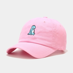 Close-up of cute blue dinosaur embroidery on a soft pink cotton baseball cap
