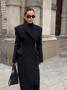 Détail d'un manteau élégant en laine noir cintré avec col à revers et poches