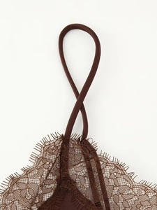 Detail of delicate lace trim and adjustable spaghetti straps on a brown satin camisole top