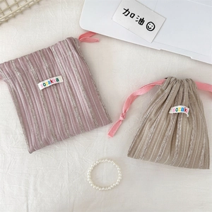 Nahaufnahme der gestreiften Kordelzug-Organizer-Taschen in Lila-Rosa und Khaki-Farbe