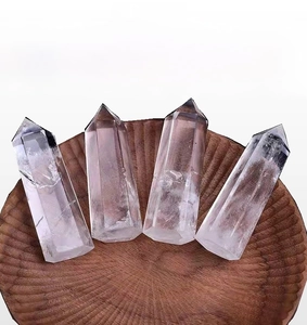 Detailed macro view of four clear quartz crystal points on a round wooden tray
