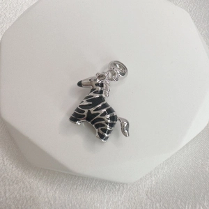 S925 sterling silver zebra pendant with black enamel stripes on white pedestal