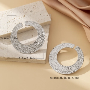 Detail of silver disc earrings showing hammered texture and 5.4cm size dimensions