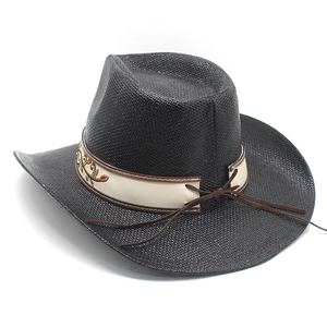 Détail d'un chapeau de cowboy noir en paille avec bande brodée et texture tressée