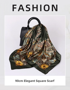 Detail view of 90cm paisley silk square scarf tied to a black crocodile texture handbag