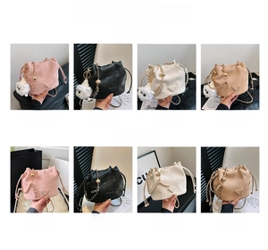 Detail view of stylish drawstring bucket bags with gold chain straps and bear charms