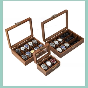 Macro view of walnut wood watch storage boxes with clear window and bronze metal buckles