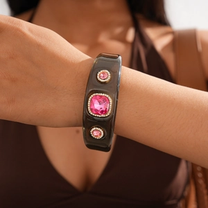 Detailed view of amber resin cuff bracelet featuring a large pink square crystal gemstone