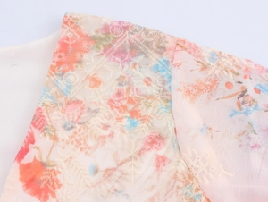 Détail macro du tissu en mousseline avec imprimé floral et broderie géométrique blanche