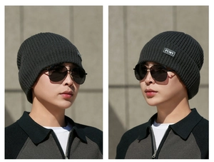 Detail view of a men's dark grey ribbed beanie with a FUMY brand label for winter warmth