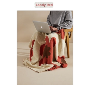 Detail of candy red floral knit blanket with soft texture and warm fleece material