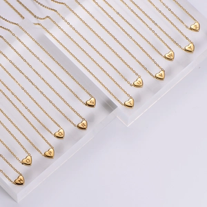 Detailed close-up of heart-shaped letter pendants in 18k gold-plated stainless steel
