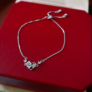 Macro shot of silver heart pendant bracelet with stones on red velvet jewelry box