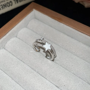 Detail of silver double-layer open ring with star elements and zircon in a jewelry box