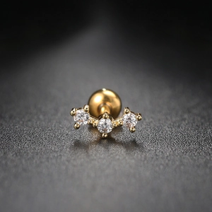 Macro detail of gold helix stud with three round zircons and screw ball back closure