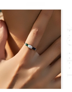 Close-up of s925 silver ring featuring an oval white opal and colorful emerald stones