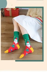Close-up of festive green Christmas socks with Santa Claus pattern and Ho Ho text