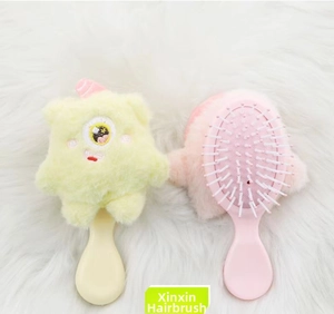 Detail view of pink and yellow plush monster hairbrushes with soft bristles and cute designs
