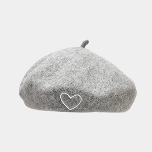 Close-up of grey wool beret featuring a delicate white heart embroidery and texture
