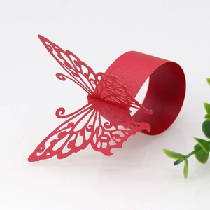 Detail of red laser-cut paper napkin ring with intricate butterfly hollow pattern
