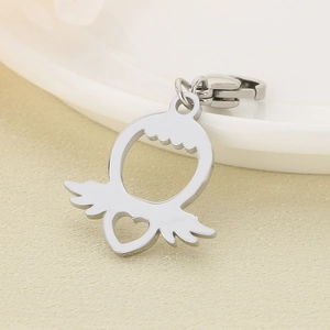 Détail macro du pendentif coeur et aile d'ange en acier inoxydable avec fermoir mousqueton
