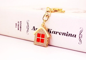 Macro shot of gold house keychain with sparkling rhinestones on a decorative book