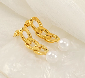 Detailed macro of gold drop earrings with bold Cuban links and large white pearls