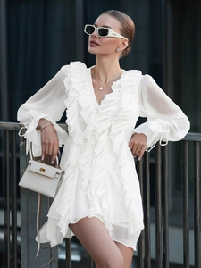 Detail of white chiffon dress with ruffled V-neckline and lantern sleeves for a romantic look