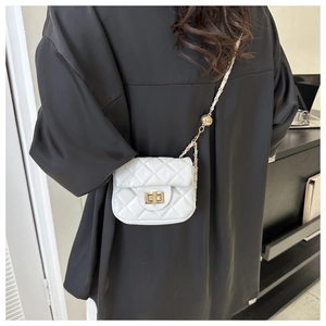 Detail of white quilted crossbody bag with golden clasp and adjustable chain strap