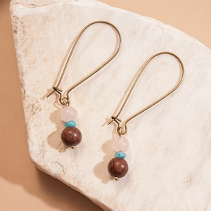 Détail de boucles d'oreilles en cuivre rétro avec perles en quartz rose et turquoise