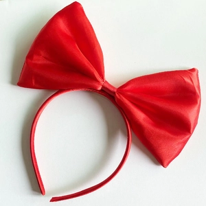 Detail of the oversized red satin bow headband for girls with smooth fabric texture