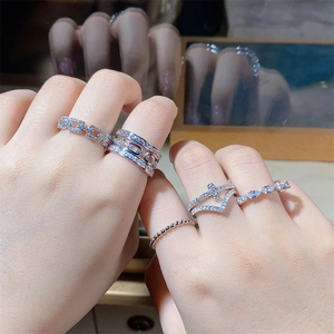 Close-up of stacked V-shaped 925 sterling silver rings with zircon pavé on a model hand