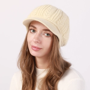 Detalle de la textura de punto de ochos crema en un gorro de invierno con visera