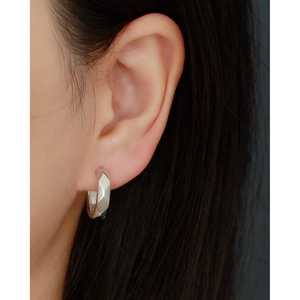 Close-up of S925 silver hoop earring with irregular facets worn on a model's ear